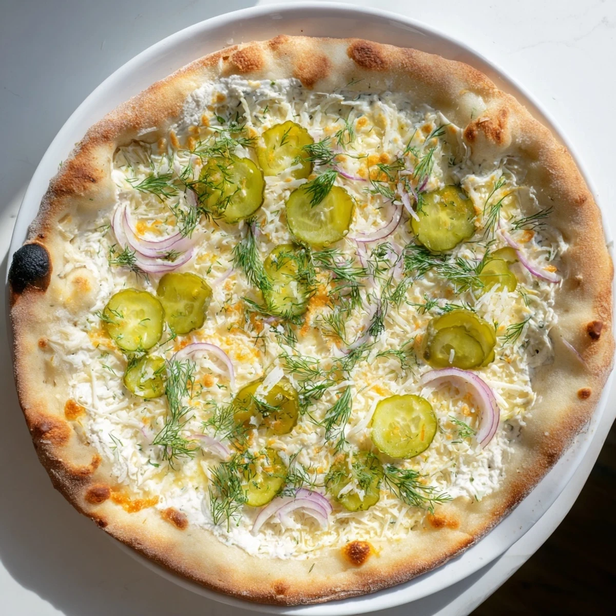 Tangy pickle pizza topped with creamy sauce, mozzarella, and crunchy dill pickles.  