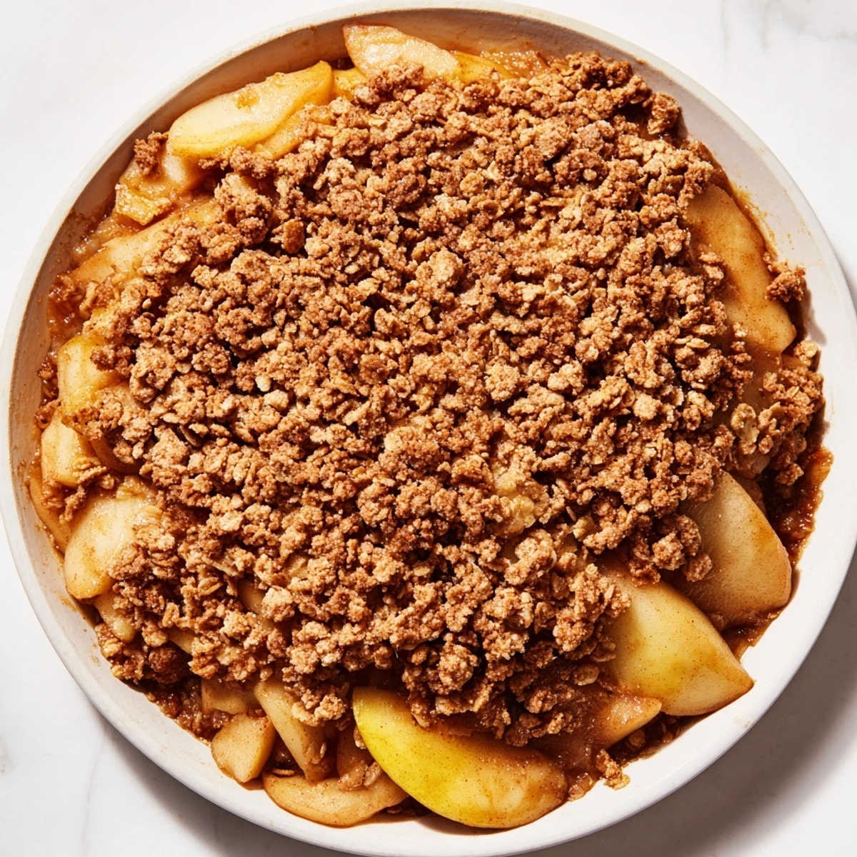 A close-up of freshly baked Apple Crisp, showcasing a perfectly crispy oat topping and juicy apples.