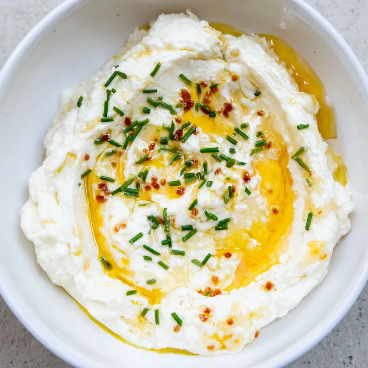Golden hot honey drizzle over a fluffy whipped ricotta dip, ready to be scooped with crostini.