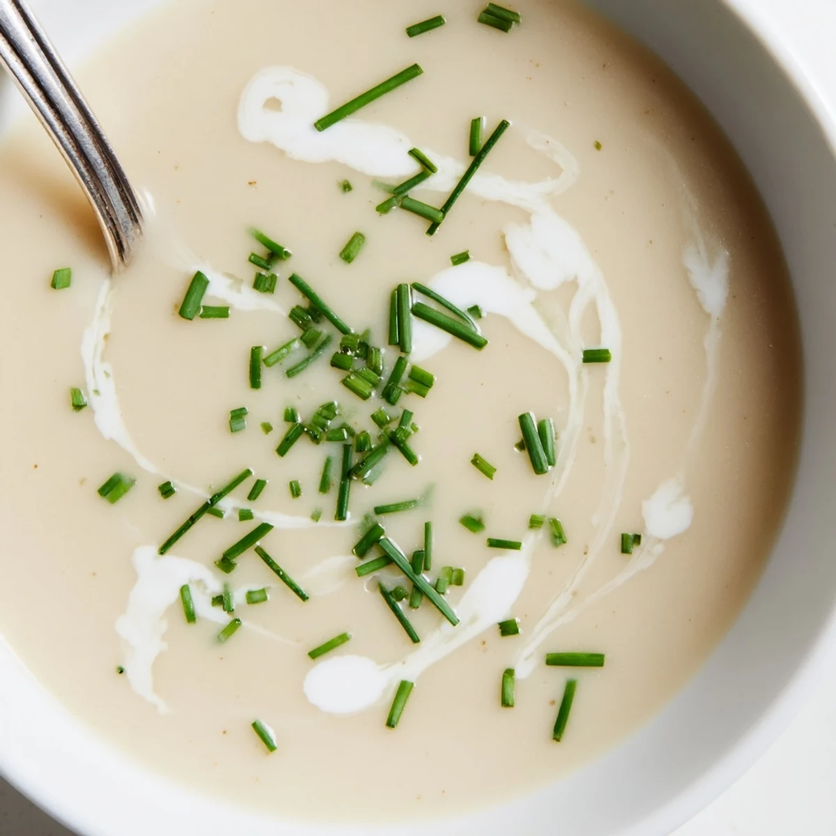 A bowl of celery root bisque with truffle oil drizzle and crusty bread.