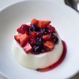 Silky smooth Panna Cotta in a glass with vibrant red berry topping.