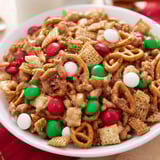 Golden and crunchy Holiday Mix, featuring Chex cereal and festive candies, ready to eat.