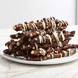 Sweet and salty chocolate covered pretzel stick stacks, arranged and ready for a party dessert.