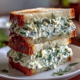 A platter of classic Kentucky Derby Benedictine tea sandwiches with cucumber and cream cheese spread, cut into elegant triangles.