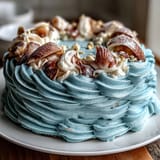 A moist vanilla Cancer Zodiac Cake, frosted with ocean blue buttercream and pearl seashells.