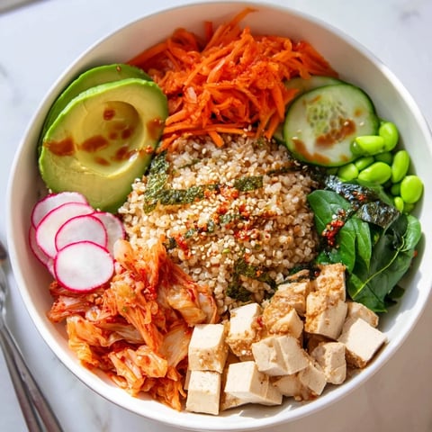 A colorful fermented vegetable bowl topped with kimchi and fresh veggies.  