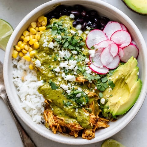 A delicious Green Enchiladas Rice Bowl topped with fresh cilantro and avocado slices.  