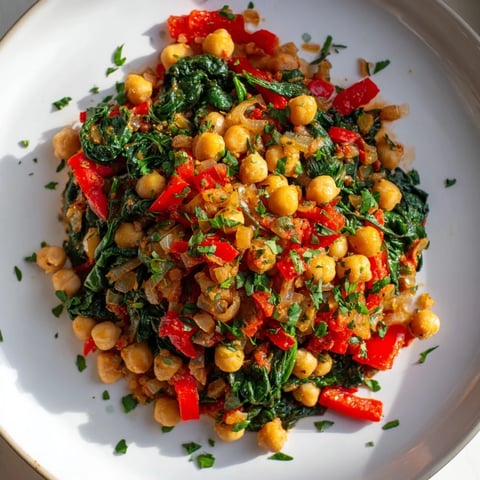 Golden, steaming Vegetarian Chickpea & Spinach Skillet, served in a cast iron pan with fresh herbs.