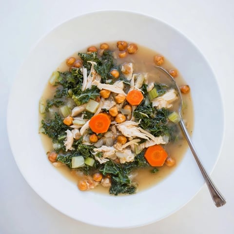 Chicken Kale Soup with Crispy Chickpeas, a warm bowl filled with nourishing ingredients, including golden chickpeas.