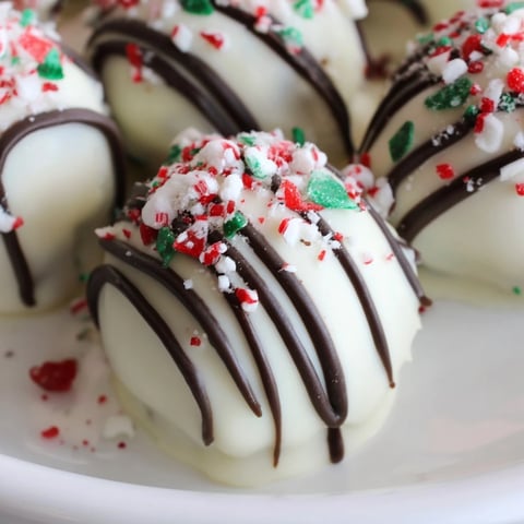 Delectable Simplified Christmas Oreo Truffles, drizzled with dark chocolate and colorful holiday sprinkles.