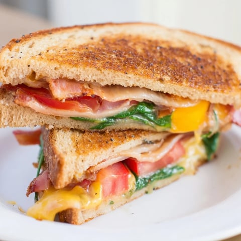 Golden, melty Turkey Bacon, Spinach & Tomato Protein Grilled Cheese, perfect for a satisfying lunch or dinner.