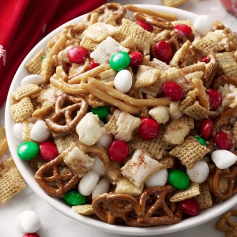 A vibrant bowl overflows with delicious Holiday Mix, a perfect snack for holiday parties.