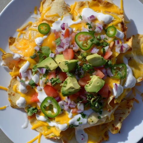 Golden, crispy pasta chips nachos piled high with melted cheese and fresh, vibrant toppings.