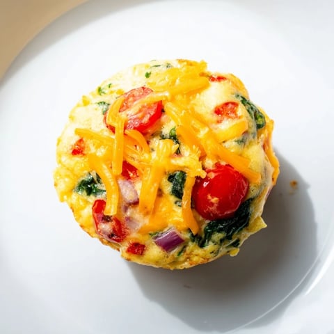 Steaming hot Veggie Egg Muffins bursting with colorful vegetables, perfect for a protein-packed morning.