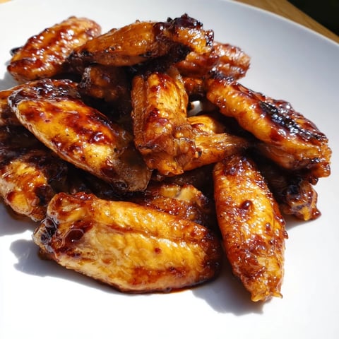 Golden-brown Baked Sticky Honey BBQ Wings glistening with a sweet, homemade sauce, ready to serve and enjoy.