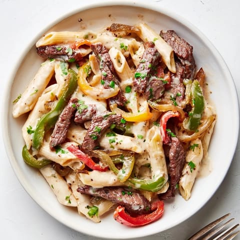 Sautéed peppers and onions blend perfectly in this Philly Cheese Steak Pasta dish.  