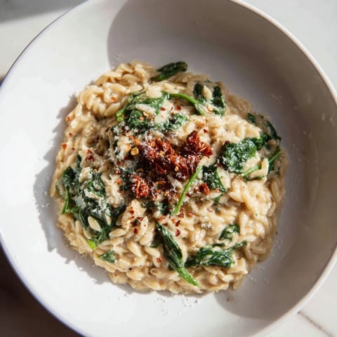 Flavorful creamy Tuscan orzo bowl with Parmesan, Italian herbs, and wilted spinach for a hearty meal.