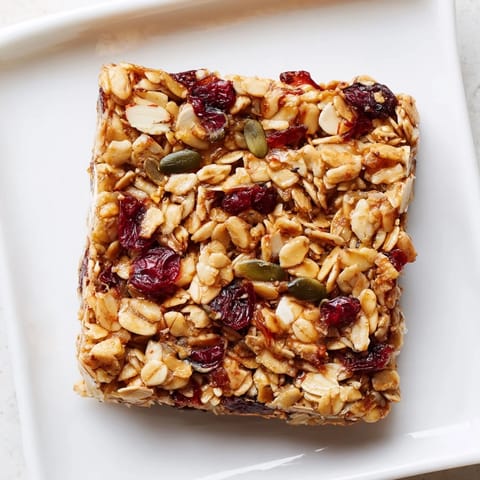 Freshly baked, chewy Roasted Pumpkin Seed & Cranberry Granola Bars, perfect for a quick and healthy breakfast.
