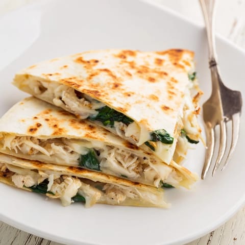 Crispy, grilled flour tortilla filled with tender shredded chicken and fresh spinach, served with a side of creamy salsa.  