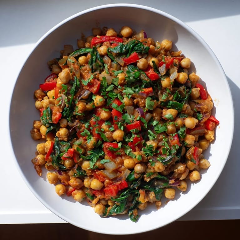 Vibrant Vegetarian Chickpea & Spinach Skillet boasts a medley of spices, tomatoes, and tender spinach.