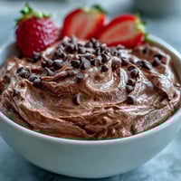 Cottage Cheese Brownie Batter Dip with fresh strawberries, apple, and banana slices for a healthy dessert platter.